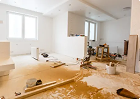 赤いスポーツカーの前で、男性がインパクトドライバーを使い、車の外装部分に作業をしている。